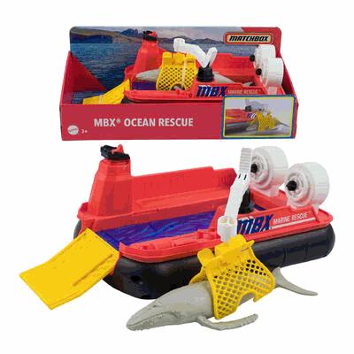Toy boat with shark model and packaging labeled 'MBX Ocean Rescue' on a white background