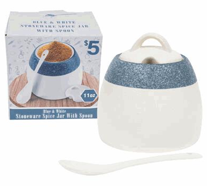 White and blue stoneware spice jar with spoon next to its packaging