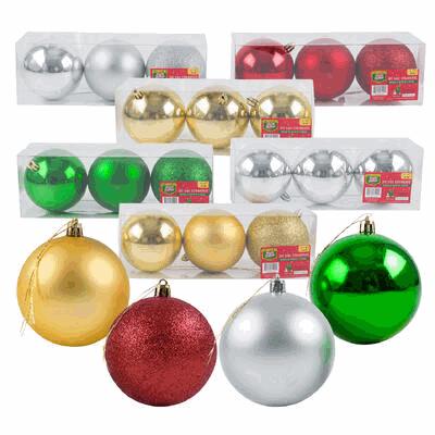 Assorted Christmas ornaments including gold, red, green, and silver in packaging on a white background.