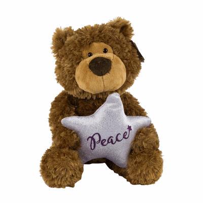 Plush teddy bear holding a star-shaped pillow with 'Peace' written on it against a white background