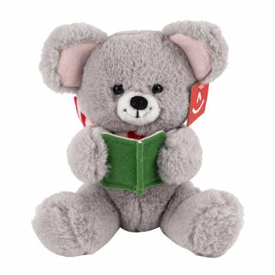 Plush teddy bear holding a green book on a white background