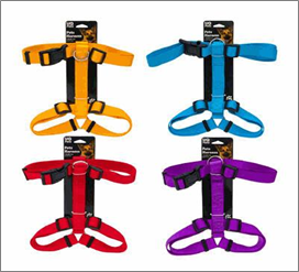 Four colorful dog harnesses on packaging with a black background